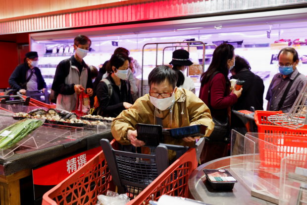 A customer wearing a mask buys fresh meat at a supermarket ahead of mass coronavirus disease (COVID-19) testing in Hong Kong, China March 1, 2022. REUTERS/Tyrone Siu