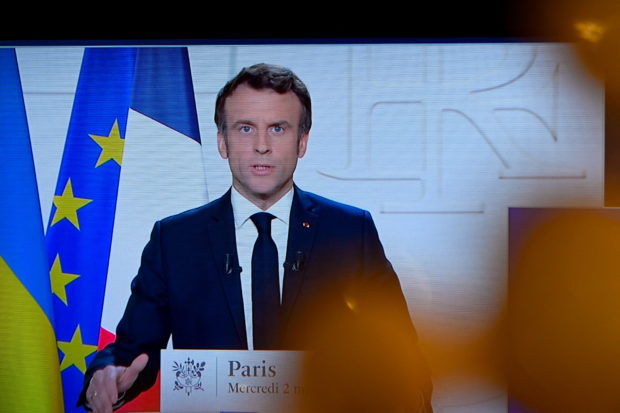 French President Emmanuel Macron appears on a screen as he delivers a speech on the Russian invasion of Ukraine, in Paris, France, March 2, 2022. REUTERS/Piroschka van de Wouw