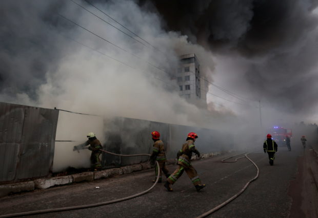 Firefighters extinguish fire at a warehouse that caught flames, according to local authorities, after shelling, as Russia's invasion of Ukraine continues, in the village of Chaiky in the Kyiv region, Ukraine March 3, 2022. REUTERS/Serhii Nuzhnen