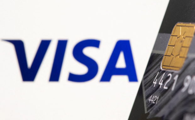 Credit card is seen in front of displayed Visa logo in this illustration taken July 15, 2021. REUTERS/Dado Ruvic/Illustration