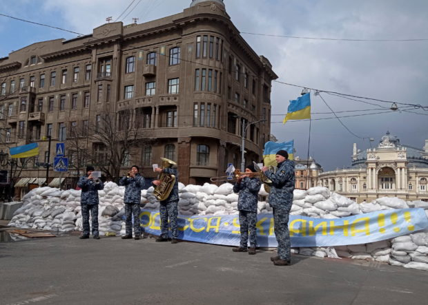 Ukrainian navy musicians perform in front of barricade made of sandbags near the opera theatre in central Odessa, Ukraine, March 8, 2022. REUTERS/Iryna Nazarchuk