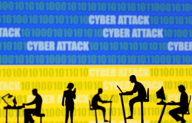 FILE PHOTO: Figurines with computers and smartphones are seen in front of the words "Cyber Attack", binary codes and the Ukrainian flag, in this illustration taken February 15, 2022. REUTERS/Dado Ruvic/Illustration/File Photo