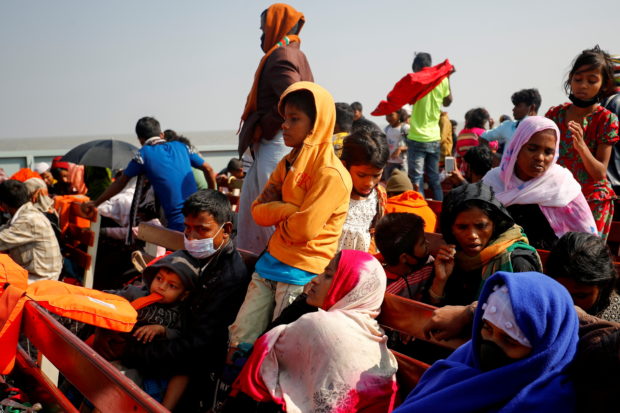 Rohingya refugees sit on wooden benches of a navy vessel on their way to the Bhasan Char island in Noakhali district, Bangladesh, December 29, 2020. REUTERS/Mohammad Ponir Hossain