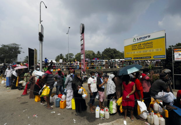 People stand in a long queue to buy kerosene oil due to shortage of domestic gas as a result of country's economic crisis, at a fuel station in Colombo, Sri Lanka  March 18, 2022. REUTERS/Dinuka Liyanawatte