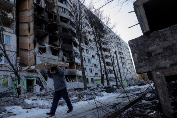 A man carries belonging out of a house that was hit by bombing in a northern district of Kharkiv as Russia's attack on Ukraine continues, Ukraine, March 24, 2022.  REUTERS/Thomas Peter