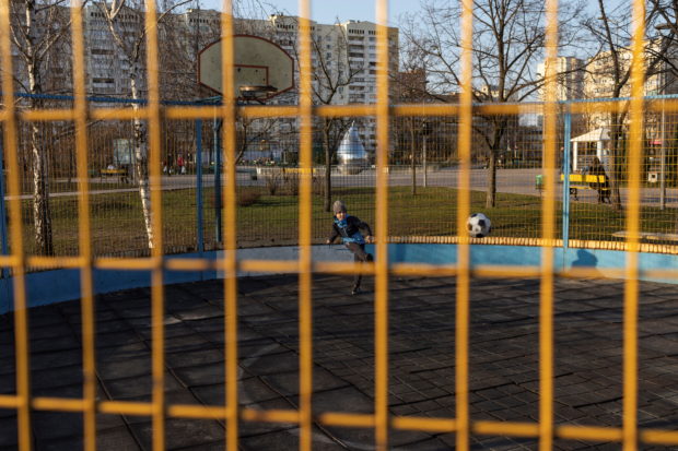 A boy plays soccer in a park, as Russia's invasion of Ukraine continues, in Kyiv, Ukraine March 25, 2022. REUTERS/Marko Djurica