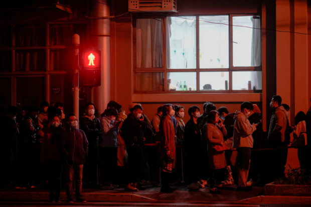 People line up near a nucleic acid testing site outside a hospital during mass testing for the coronavirus disease (COVID-19) amid the COVID-19 pandemic, in Shanghai, China March 27, 2022. REUTERS/Aly Song