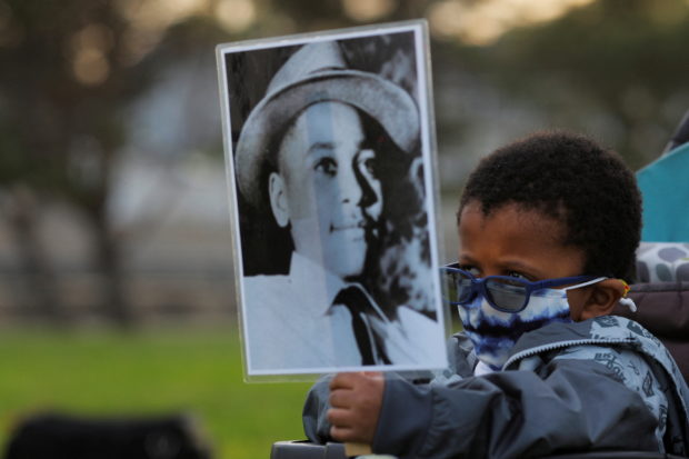 FILE PHOTO: Four-year-old Senty Banutu-Gomez holds a photograph of Emmett Till, a 14-year-old Black boy who was lynched in 1955, at a vigil on the one year anniversary of the murder of George Floyd while in Minneapolis police custody, in Lynn, Massachusetts, U.S., May 25, 2021.    REUTERS/Brian Snyder/File Photo