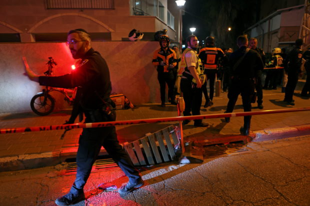 Israeli security and medical personnel secure the scene of an attack in which people were killed by a gunman on a main street in Bnei Brak, near Tel Aviv, Israel, March 29, 2022. REUTERS/Nir Elias