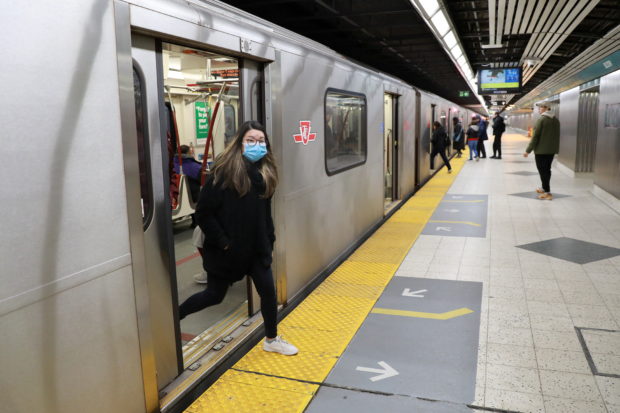 A woman wearing a mask exits a subway train in Toronto, Ontario, Canada on March 17, 2020. REUTERS/Chris Helgren