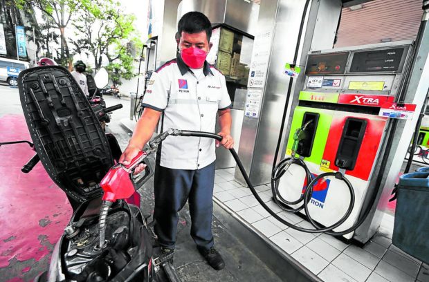 Man filling up a gas stank at a gas station, FOR STORY: Jeepney drivers press government to release fuel subsidy