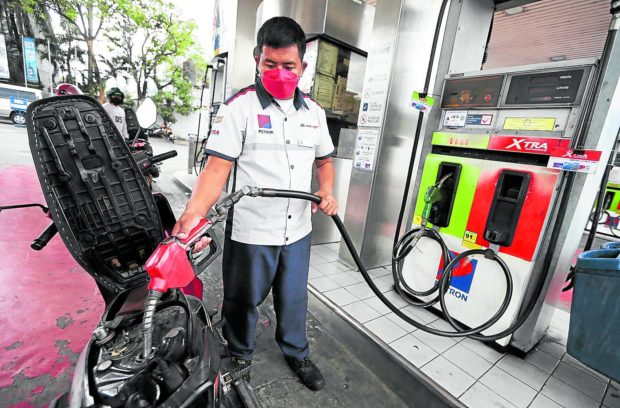 OIL PRICE HIKE / FEBRUARY 21, 2022 A man fills up a motorcycle gas tank at a gasoline station in East Avenue, Quezon City on February 21, 2022. Another fuel price hike is expected in the coming days among main gasoline companies. INQUIRER PHOTO / NINO JESUS ORBETA oil fuel aid middle class