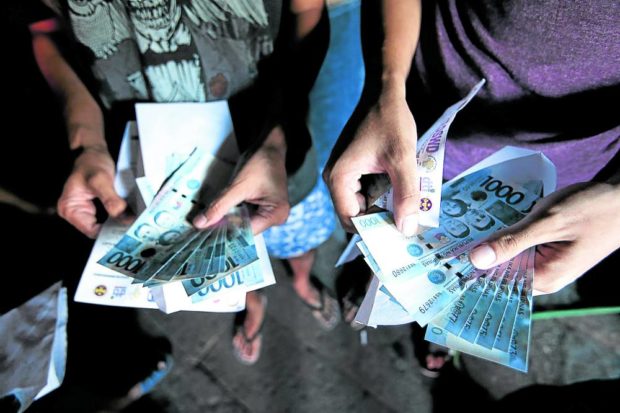 Closeup of hands of recipeints of cash aid. STORY: DSWD delists over 17,000 4Ps grantees in Central Visayas
