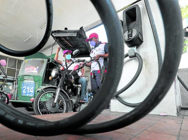 Tricycle at a gas station. STORY: Oil firms set biggest increase in fuel prices