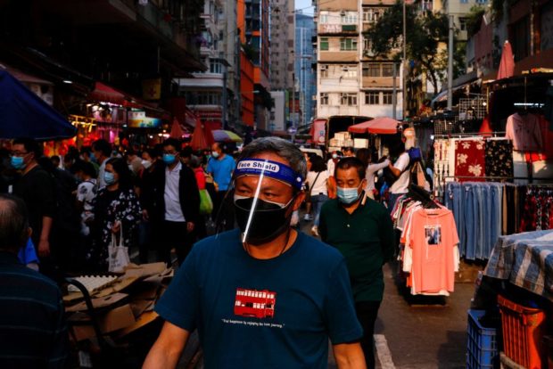 A man wearing face mask and shield shops at wet market during the coronavirus disease