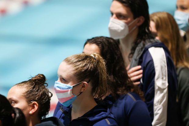 Andie Myers wears a facemask with a transgender pride flag