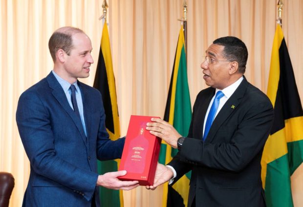 Jamaica's Prime Minister Andrew Holness presents Britain's Prince William with a bottle of Appleton Estate Ruby