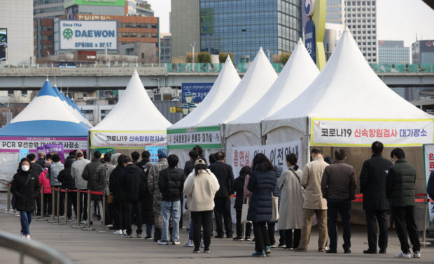 People line up for COVID-19 tests at a testing facility in central Seoul