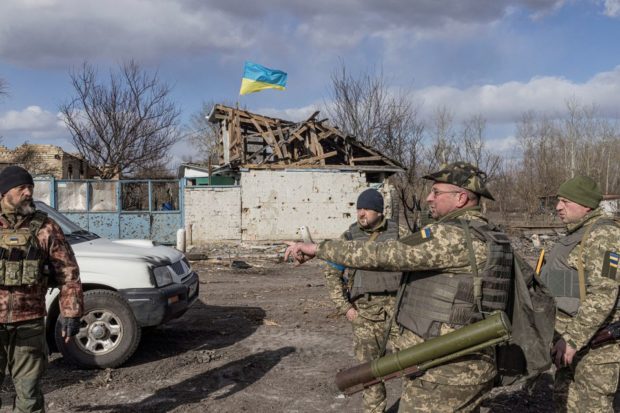 Ukranian servicemen stand in the village of Lukyanivka