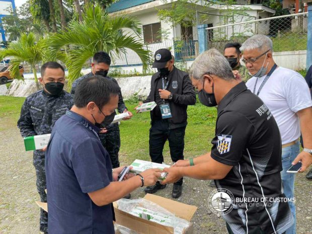 Authorities inspect the P20 million worth of smuggled cigarettes confiscated in Davao del Sur on March 24, 2022 (Photo from BOC)
