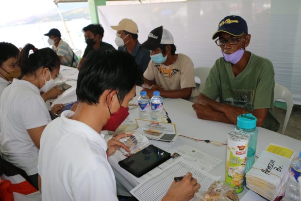 Fishermen in Subic town, Zambales province receive their fuel subsidy in the form of cash cards during the launch of the program at Bulungan fish port on Monday, March 21