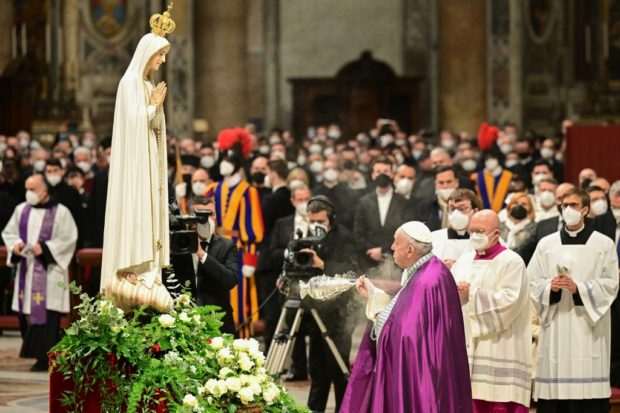 Pope Francis (R) swings a thurible of incense before a statue of Our Lady of Fatima. STORY: Pope leads prayer for peace between Russia, Ukraine