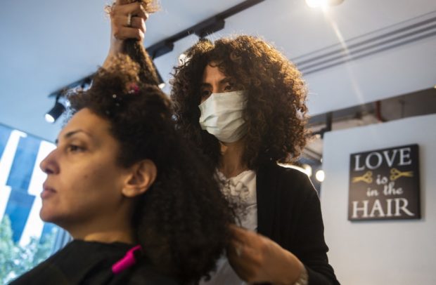 EDITORS NOTE: Graphic content / Rola Amer, hairstylist at the "Curly Studio", styles a client's hair at her salon in Egypt's capital Cairo on March 2, 2022. - "Shaggy," "messy," "unprofessional." Natural curls were once looked down upon in Egypt, where Western beauty standards favoured sleek, straight locks. Now, things are changing. (Photo by Mohamed Hossam / AFP)