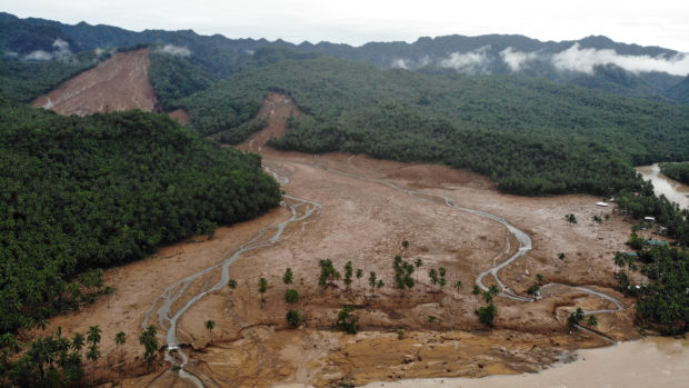 An aerial view shows the scene of a landslide which hit the village of Kantagnos in Baybay town, Leyte province on April 13, 2022, following heavy rains brought about by tropical storm Megi. (Photo by BOBBIE ALOTA / AFP)