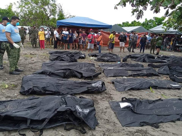 Rescuers gather body bags containing dead bodies, victims of a landslide that slammed the village of Pilar in Abuyog town, Leyte province on April 13, 2022, days after heavy rains inundated the town brought about by Tropical Storm Megi. (Photo by STRINGER / AFP)