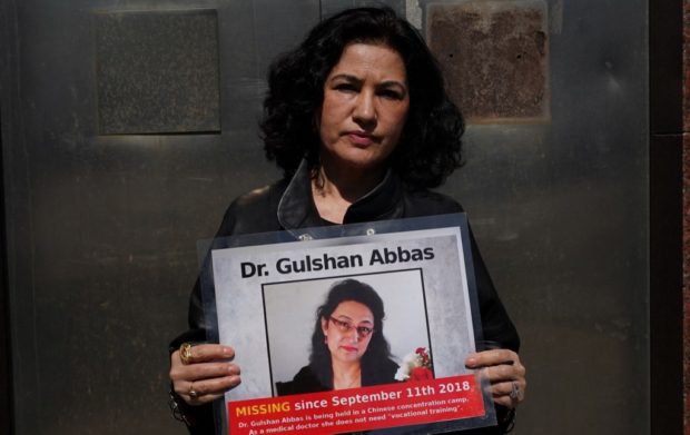 Campaign for Uyghurs Executive Director Rushan Abbas holds a photo of her sister, Gulshan Abbas who is currently imprisoned in a camp during a rally in New York on March 22, 2021. - The rally is for Uyghur Freedom, with participants calling on President Joe Biden to "combat the Uyghur genocide through diplomacy and economic pressure". (Photo by TIMOTHY A. CLARY / AFP)