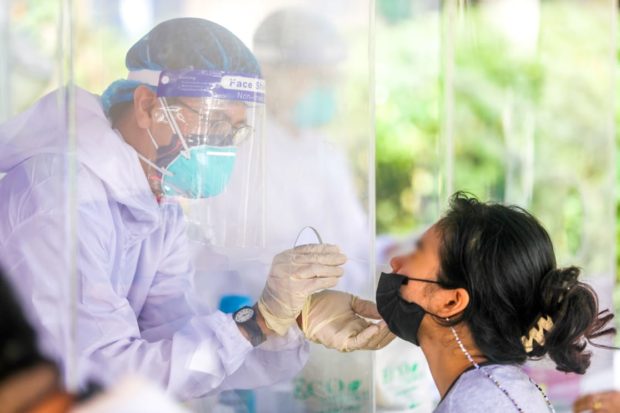 A volunteer medical frontliner from the Office of the Vice President's Swab Cab administers a nose swab on a patient. Image from Facebook / VP Leni Robredo covid-19 cases ncr covid-19 fresh active cases