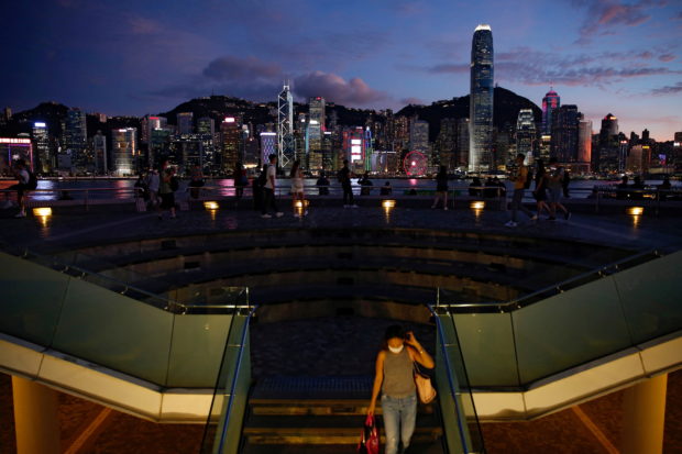 FILE PHOTO: People enjoy the sunset view with a skyline of buildings during a meeting on national security legislation, in Hong Kong, China June 29, 2020. REUTERS/Tyrone Siu/Files/File Photo
