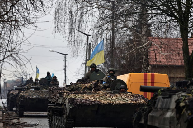 Ukrainian soldiers are pictured on their tanks as they drive along the street, amid Russia's invasion on Ukraine, in Bucha, in Kyiv region, Ukraine April 2, 2022. REUTERS/Zohra Bensemra