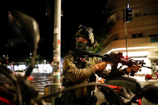 FILE PHOTO: Israeli security personnel work near the scene of a fatal shooting attack near a bar in Tel Aviv, Israel April 7, 2022. REUTERS/Corinna Kern