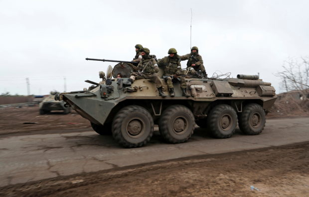 Service members of pro-Russian troops ride an armoured personnel carrier during Ukraine-Russia conflict on the outskirts of the southern port city of Mariupol, Ukraine April 12, 2022. REUTERS/Alexander Ermochenko