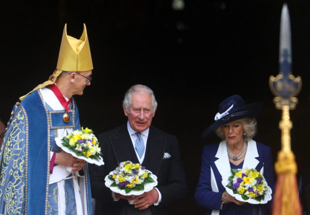 Britain's Prince Charles and Camilla, Duchess of Cornwall, hold bouquets as they walk out of St George's Chapel after the Royal Maundy Service at Windsor Castle, in Windsor, Britain April 14, 2022. REUTERS/Hannah McKay