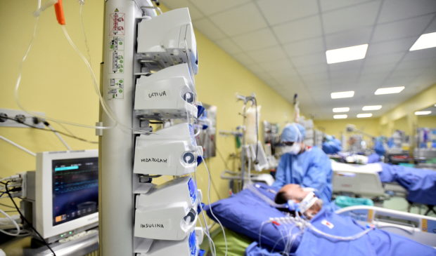 FILE PHOTO: Member of the medical staff in protective suit treats a patient suffering from coronavirus disease (COVID-19) in an intensive care unit at the San Raffaele hospital in Milan, Italy, March 27, 2020. REUTERS/Flavio Lo Scalzo