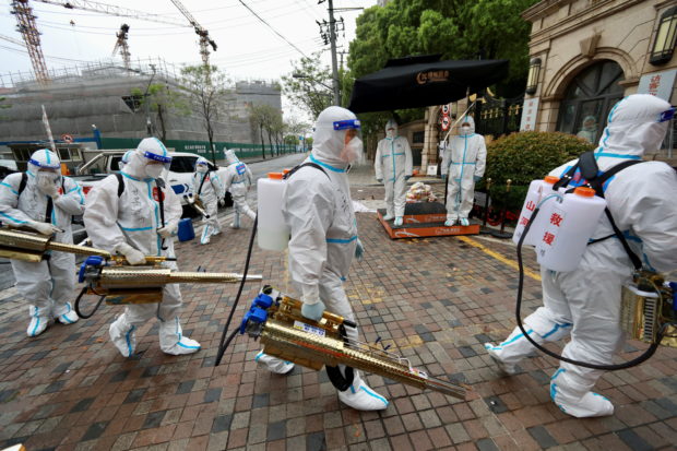 Volunteers in protective suits prepare to disinfect a residential compound in Huangpu district, to curb the spread of the coronavirus disease (COVID-19), in Shanghai, China April 14, 2022. China Daily via REUTERS