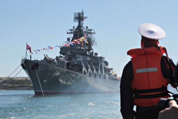 FILE PHOTO: A sailor looks at the Russian missile cruiser Moskva moored in the Ukrainian Black Sea port of Sevastopol, Ukraine 10, 2013. REUTERS/Stringer/File Photo/File Photo