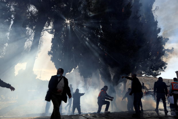Palestinians put out a fire following a clash with Israeli security forces at the compound that houses Al-Aqsa Mosque, known to Muslims as Noble Sanctuary and to Jews as Temple Mount, in Jerusalem's Old City April 22, 2022. REUTERS/Ammar Awad