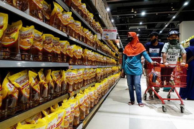 People shop for cooking oil made from oil palms at a supermarket in Jakarta, Indonesia, March 27, 2022. REUTERS/Willy Kurniawan