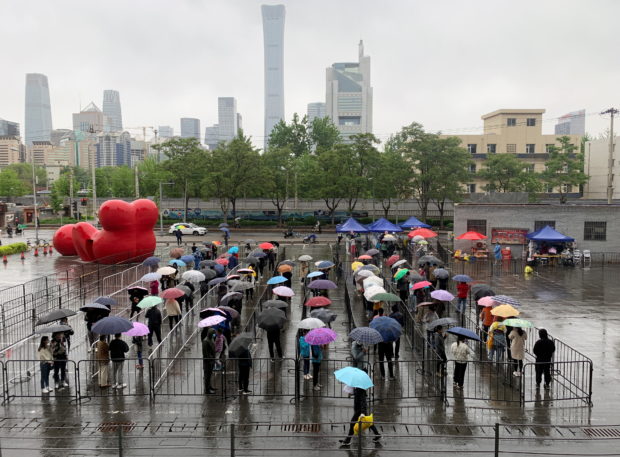 People line up at a makeshift nucleic acid testing site amid a mass testing for the coronavirus disease (COVID-19) in Chaoyang district of Beijing, China April 27, 2022. REUTERS/Thomas Suen