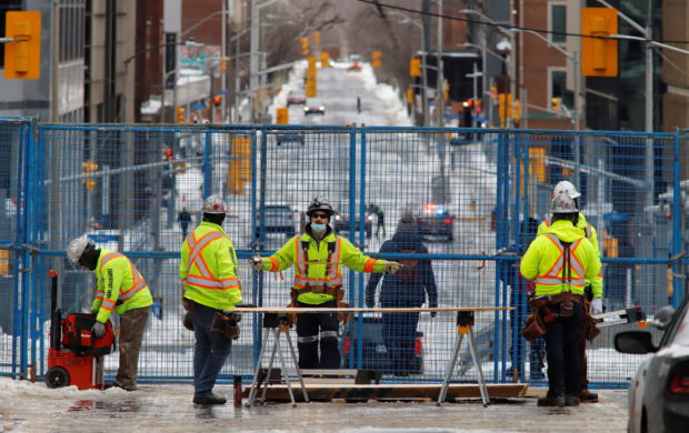 FILE PHOTO: Workers reinforce a fence inside a protected zone around Parliament Hill after police ended three-weeks of occupation of the capital by protesters seeking to end coronavirus disease (COVID-19) vaccine mandates in Ottawa, Ontario, Canada, February 21, 2022. REUTERS/Patrick Doyle/File Photo