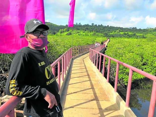 BRIDGE OF HOPE Village watchman Musli Jumli stands guard on the newly constructed 500-meter bridge that links Marang-Marang Island to Isabela City’s mainland. Jumli, who used to swim across the sea to go to school, sees the bridge as a hope for their community’s future.—JULIE S. ALIPALA