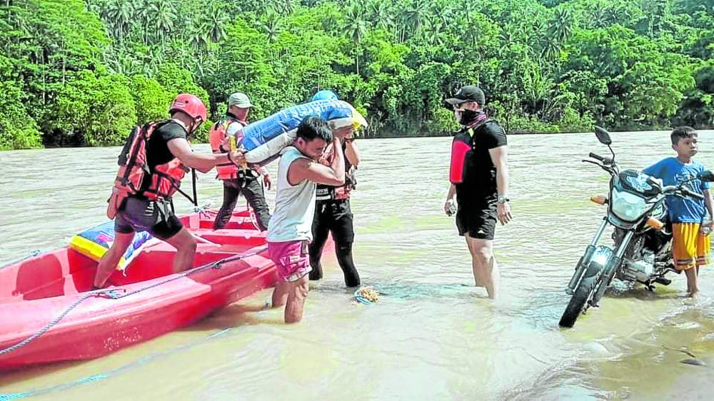 AID DELIVERY Rescue teams from the Davao Oriental provincial government use boats to reach flooded villages in Cateel and deliver food packs to communities isolated by the collapse of a bridge in the town. —PHOTO COURTESY OF MARK OLIVER ALVITE