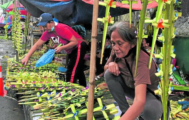 Despite the drizzle, vendors outside Our Mother of Perpetual Help church in Davao City sell palm fronds shaped into crosses on Sunday. STORY: 16 Davao City churches open for Holy Week