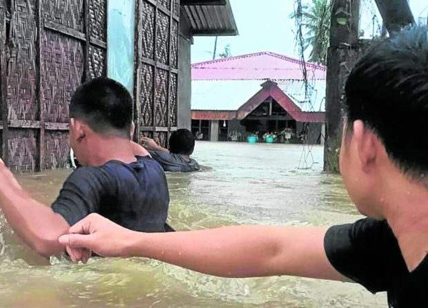 Residents of Baybay City navigate through rising floodwater to seek safer grounds on Sunday. STORY: Agaton kills 25, leaves 8 missing in Visayas, Mindanao
