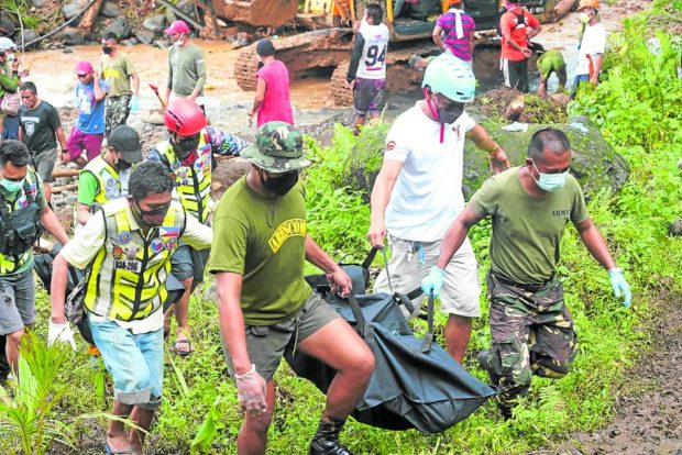  Rescue workers on Wednesday carry body bags containing the retrieved remains of victims of a landslide. STORY: Agaton: Mud keeps yielding bodies