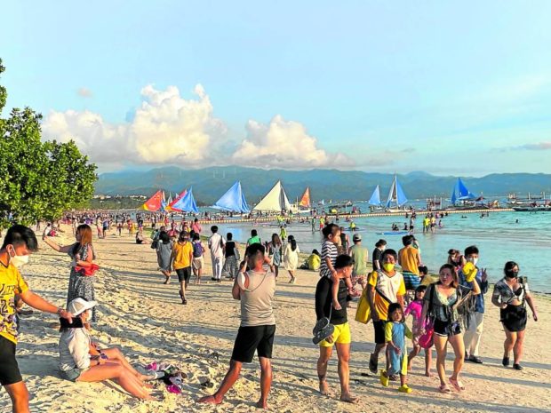 Tourists gather at the main beach on Boracay Island on Good Friday to watch the sunset. The resort island in Malay, Aklan, hosted its biggest number of visitors amid the pandemic during this year’s Holy Week as the government started relaxing travel restrictions. STORY: No clear rule to limit Boracay tourists – Aklan execs