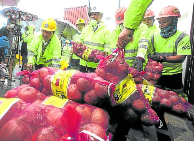 Customs personnel with smuggled onion. STORY: DOJ orders NBI to probe veggie smuggling